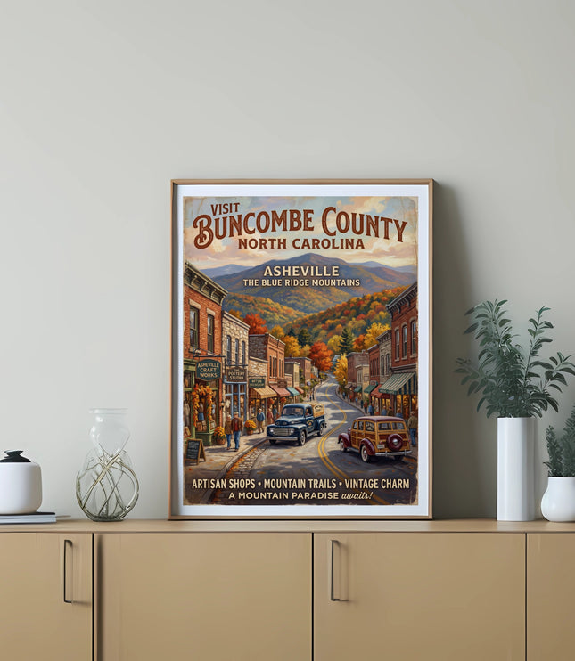 Poster of Asheville, North Carolina, featuring vintage cars and shops along a mountain road.