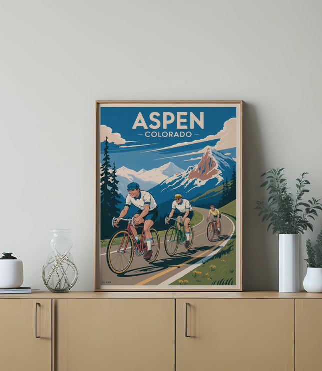 Three cyclists ride along a mountain road with "ASPEN COLORADO" text above.