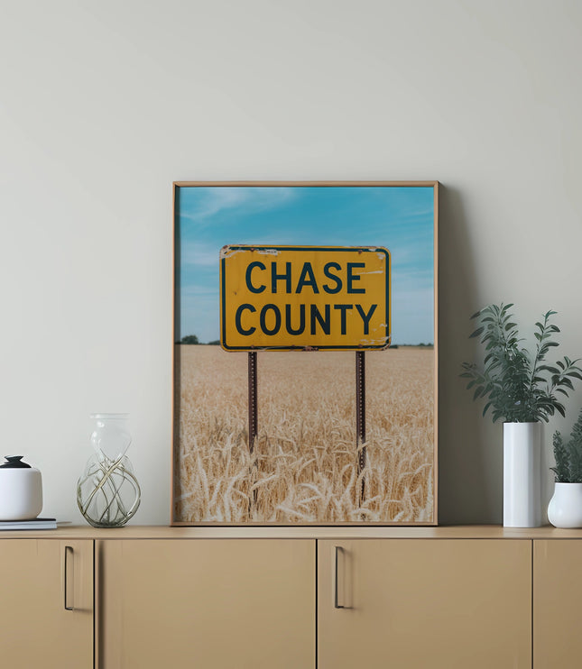 Yellow "Chase County" sign in a golden wheat field.